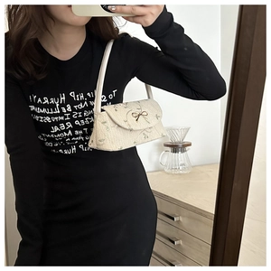 Détail du sac à main tissé crème avec broderie florale verte et boucle en forme de nœud