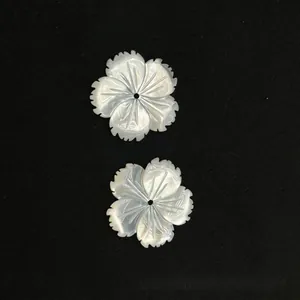 Detail of hand-carved petal-shaped sea shell charms with iridescent pearly luster for DIY