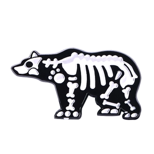 Detailed view of polar bear skeleton enamel pin with black background and white bone details