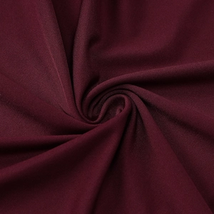 Close-up of deep burgundy ribbed knit fabric showing fine vertical texture and soft drapes