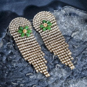 Detail of silver long tassel earrings with green flowers and sparkling crystals