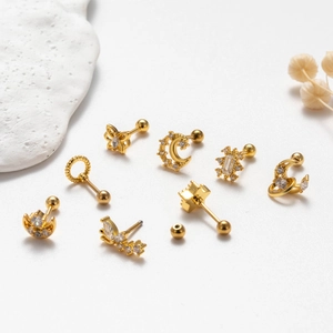 Detailed view of gold stainless steel stud earrings featuring moon star and butterfly motifs