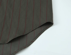 Detail of curved hem stitching on dark grey striped cotton shirt with red vertical lines