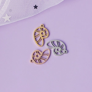 Détail de pendentifs nautiles ajourés en finitions métalliques or argent et or rose