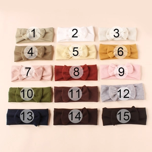 Flat lay of 15-color waffle knit baby headbands with bows arranged in a neat 3x5 matrix