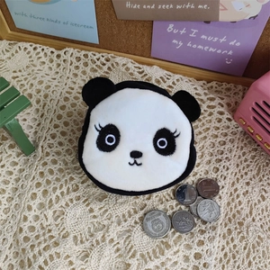 Mini panda plush coin purse on a lace mat with decorative miniature props and coins