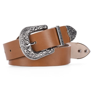 Detail of vintage brown leather belt with ornate silver floral engraved metal buckle