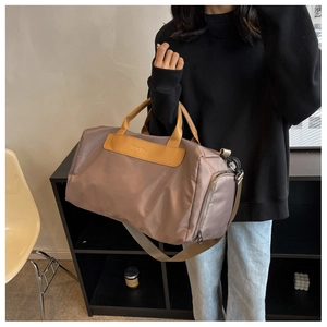 Brown nylon travel bag with yellow PU leather handles shown in a lifestyle home setting