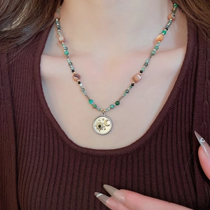 Détail du collier bohème avec pendentif céleste sur un fil de perles colorées