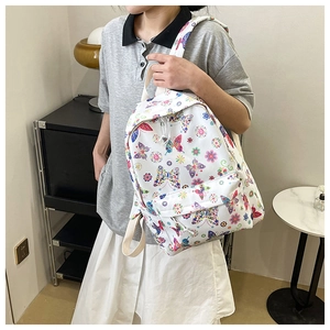 Dettaglio delle stampe colorate di farfalle e fiori su questo zaino scolastico bianco