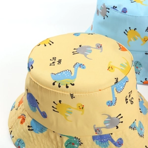 Close-up of yellow baby sun hat featuring colorful dinosaur prints and cute text embroidery