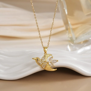 Macro view of flying hummingbird pendant with white zircon pavé and marquise tail feathers