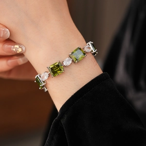 Detail of luxury emerald green square zircon bracelet on wrist with silver settings