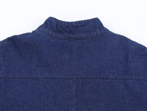 Detailed macro view of dark indigo denim fabric with precise stitching and twill texture