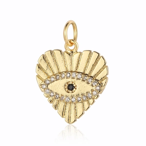 Close-up of a heart-shaped gold pendant with cubic zirconia eye motif and radial texture