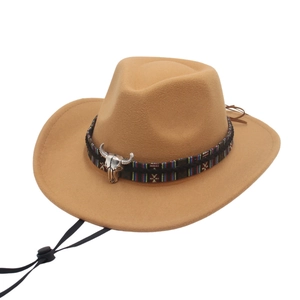 Dettaglio cappello cowboy in lana con emblema testa di toro argento e nastro stile etnico