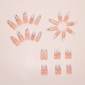 Macro shot of French pink gradient press-on nails with heart patterns and 3D bow gems