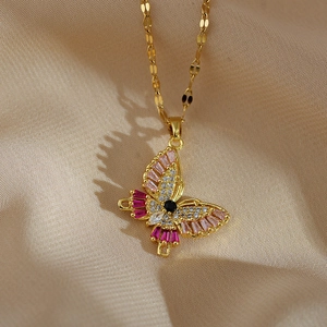 Detailed close-up of a butterfly pendant necklace with pink and clear zircon in gold finish