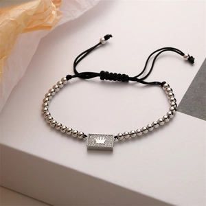 Close-up of adjustable woven crown bracelet featuring micro-pave zircons on a silver plaque