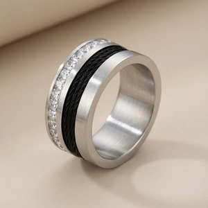Macro shot of a brushed steel ring with black cable inlay and pavé zircon stones
