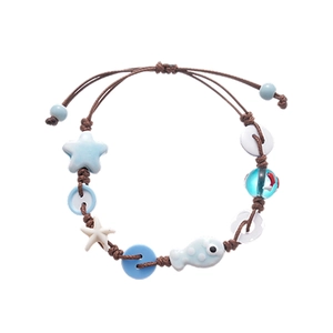 Handmade woven bracelet with ceramic star and fish pendants in seaside vacation style