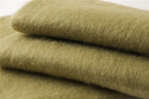 Vue macro d'un foulard en mohair vert olive doux avec une texture brossée et moelleuse
