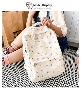 Floral canvas backpack detail featuring pink flower prints and front pocket on beige fabric