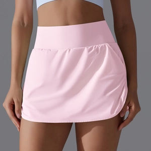 Detail view of pink high-waisted tennis skirt with wide elastic waistband and flared pleats