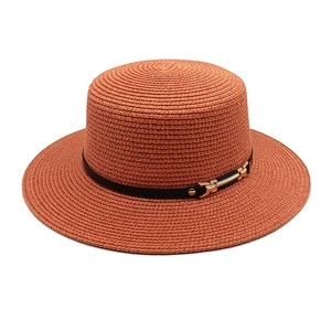 Vue détaillée du chapeau de paille orange avec texture tissée et boucle dorée chic