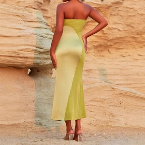 Dettaglio di un maxi abito in raso verde con cuciture color-block e design a schiena scoperta