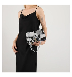Detail of checkered chain bag with rhinestone buckle and silver shoulder strap