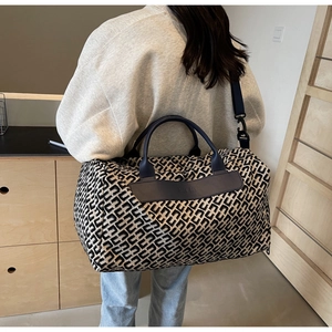 Vista posteriore di una modella con la borsa da viaggio monogramma grande e le sue dimensioni