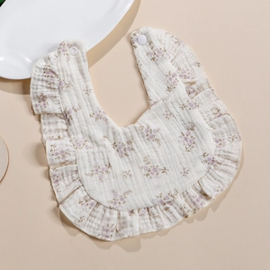 Detail of 4-layer cotton muslin baby bib with purple floral print and ruffle edges