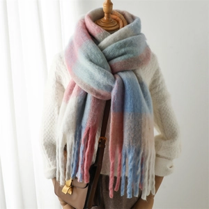 Detail shot of winter thick striped plaid scarf with soft tassels on display