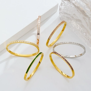 Detail of diverse gold stainless steel bangles with colorful square gemstones
