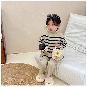 Detail of pink flower handbag with pearl handle and kids striped knitted sweater