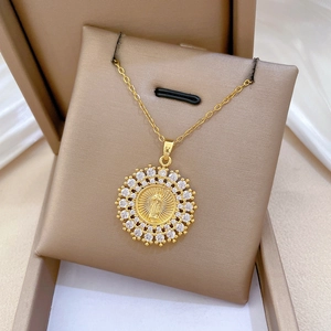 Detail of gold necklace with circular portrait pendant and sparkling crystal halo