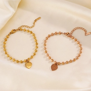Golden heart charm bead bracelet on silk, featuring Eternal Love engraving detail