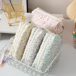 Floral quilted pencil cases in four pastel colors arranged in a white wire basket