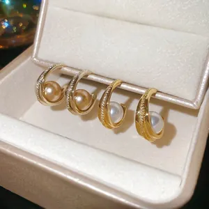 Elegant C-shaped pearl stud earrings with sparkling cubic zirconia on a gold plated base