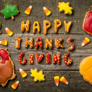 Close-up of Thanksgiving leaf and pumpkin cookies on rustic wood background