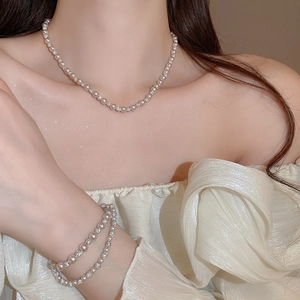 Detail of elegant pearl necklace and matching bracelet set with crystal accents