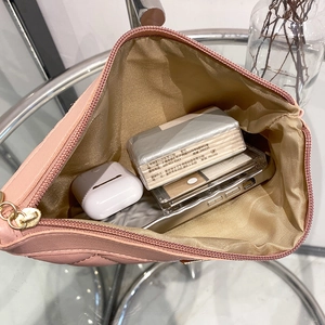 Pink quilted clutch bag with zipper closure showing spacious interior for daily items
