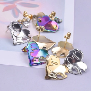 Macro detail of abstract heart stud earrings showing metal texture and butterfly backings
