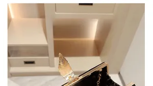 Macro shot of elegant black velvet clutch featuring a gold feather-shaped metal clasp