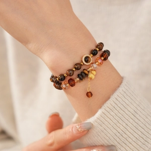 Gros plan du bracelet double couche en œil de tigre avec accents dorés et cristaux