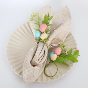 Easter egg napkin rings set with faux leaves and textured fabric on a white plate