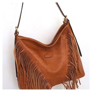 Détail du sac à bandoulière en similicuir marron avec de longues franges et métal doré