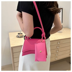 Détail du sac à main rose avec mini pochette assortie et design à base incurvée