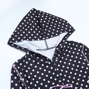 Detail of polka dot hoodie showing smooth zipper and pink artistic letter print